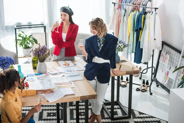 Fashion designers drinking champagne — Stock Photo