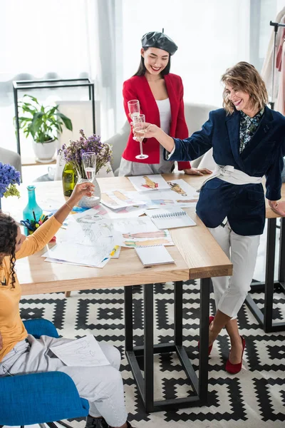 Fashion designers drinking champagne — Stock Photo