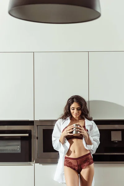 Donna in lingerie con caffè in cucina — Foto stock