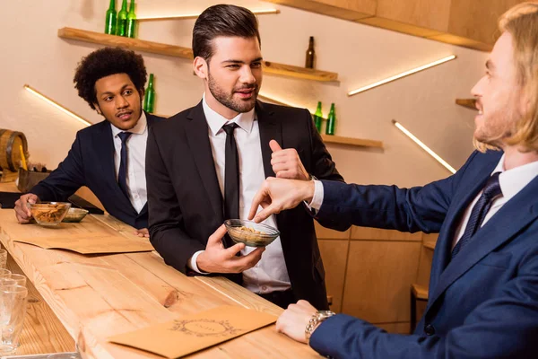 Hommes d'affaires manger collation dans le bar — Photo de stock