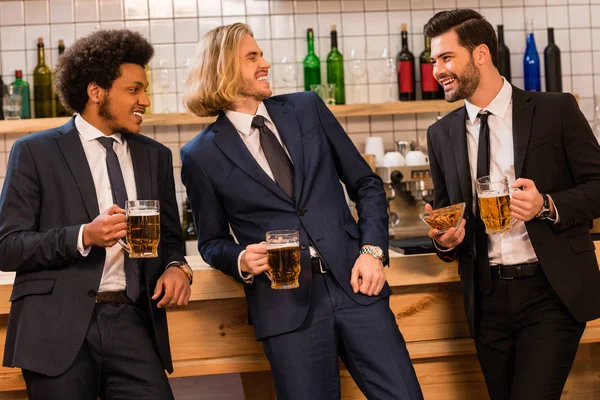 Hombres de negocios bebiendo cerveza en el bar - foto de stock