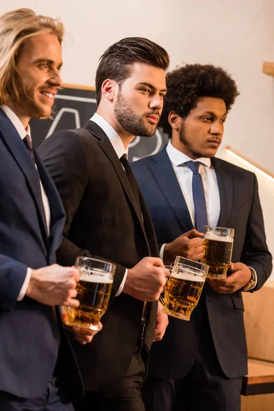 Businessmen drinking beer in bar — Stock Photo