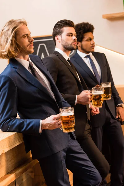 Hombres de negocios bebiendo cerveza en el bar - foto de stock