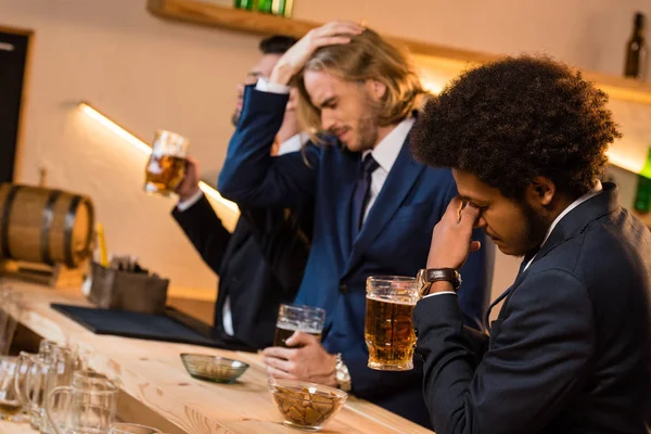 Hombres de negocios bebiendo cerveza en el bar - foto de stock