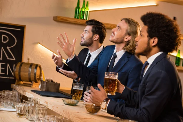 Hombres de negocios bebiendo cerveza en el bar - foto de stock