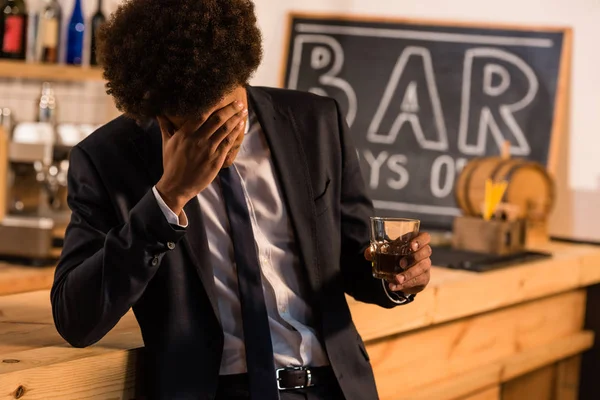 African american businessman drinking whisky — Stock Photo