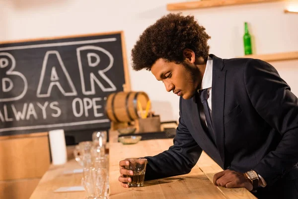 Homme d'affaires afro-américain buvant du whisky — Photo de stock