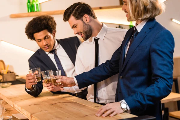 Hombres de negocios bebiendo whisky en el bar - foto de stock