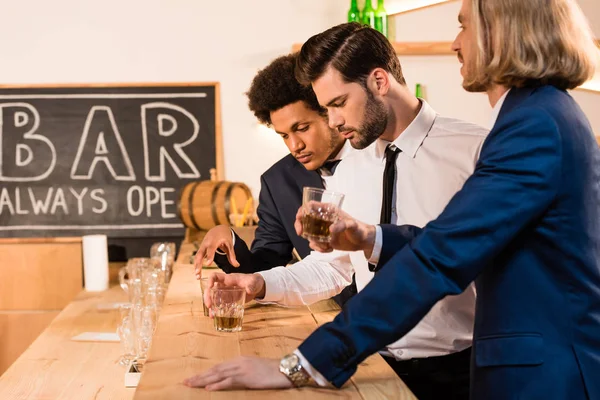 Uomini d'affari che bevono whisky al bar — Foto stock