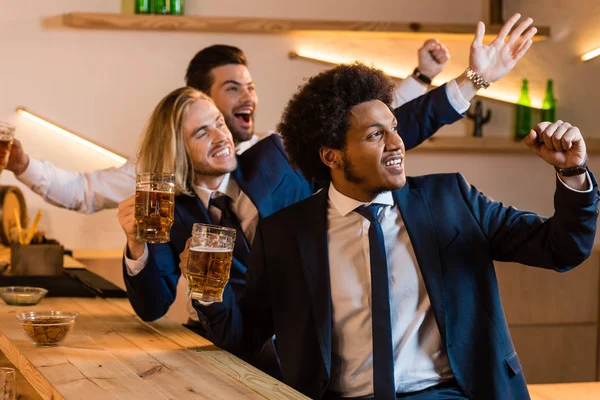Hombres de negocios viendo partido de fútbol en el bar - foto de stock