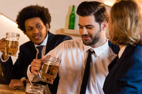 Hombres de negocios bebiendo cerveza en el bar - foto de stock