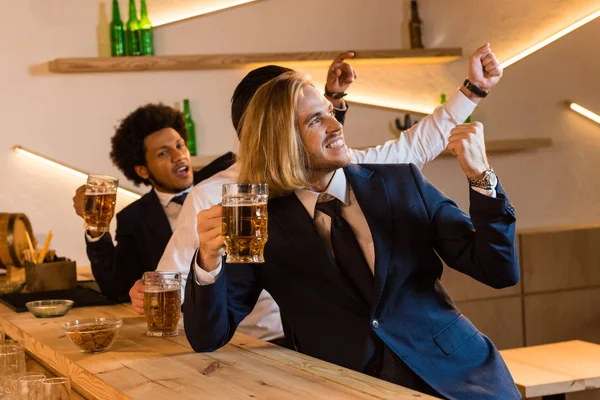 Hombres de negocios viendo partido de fútbol en el bar - foto de stock