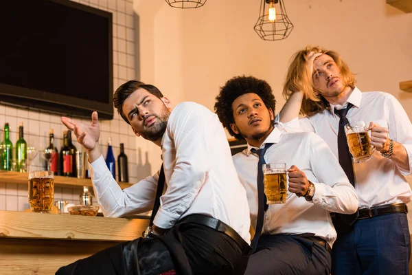 Hombres de negocios bebiendo cerveza en el bar - foto de stock