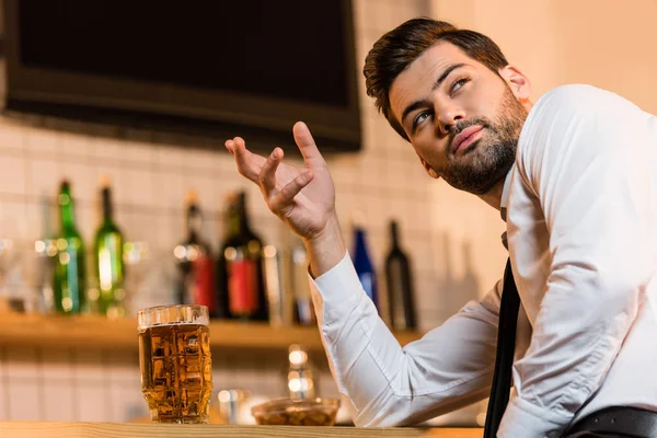 Бизнесмен с пивом в баре — стоковое фото