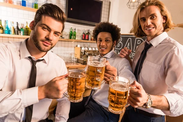 Businessmen drinking beer in bar — Stock Photo