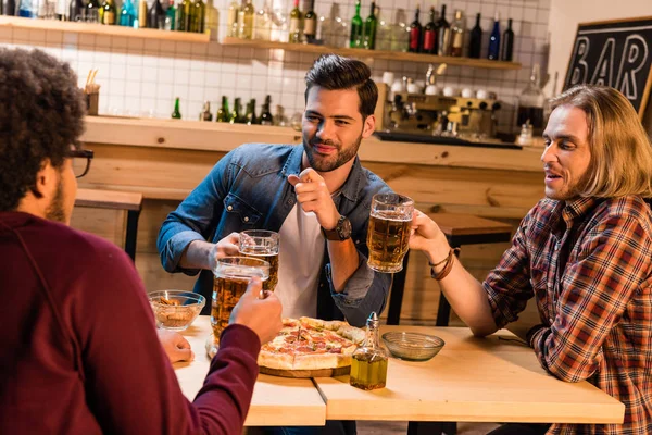 Amici con pizza e birra al bar — Foto stock