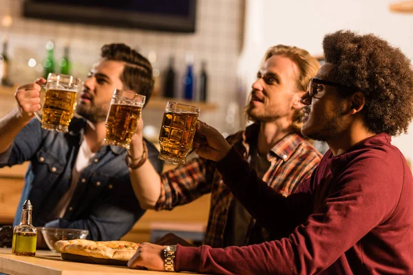 Amici con pizza e birra al bar — Foto stock