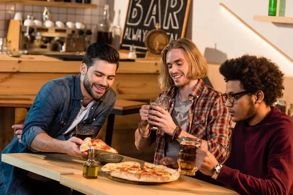 Amigos con pizza y cerveza en el bar — Stock Photo