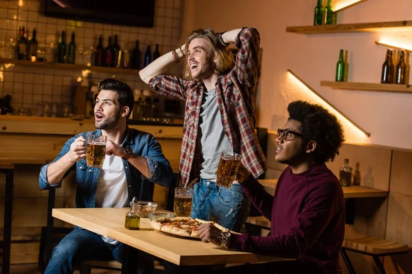 Amici con birra guardando partita nel bar — Foto stock