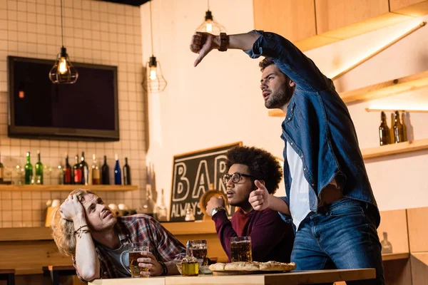 Amici a guardare la partita di calcio nel bar — Foto stock