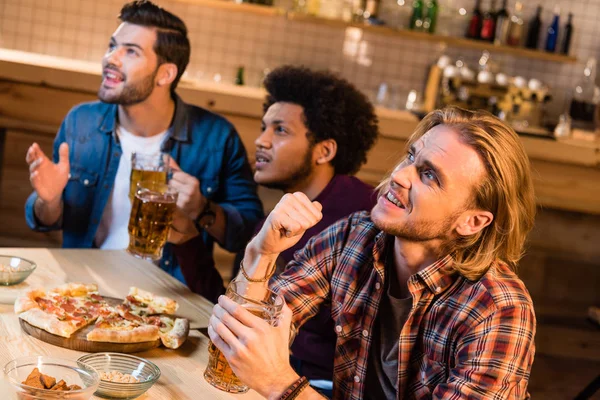 Friends watching football game in bar — Stock Photo