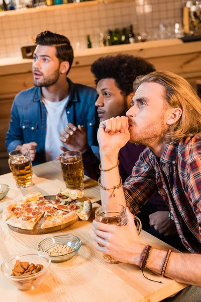 Friends with pizza and beer in bar — Stock Photo