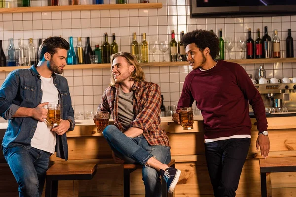 Friends drinking beer in bar — Stock Photo