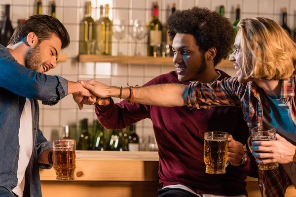 Friends with beer stacking hands — Stock Photo