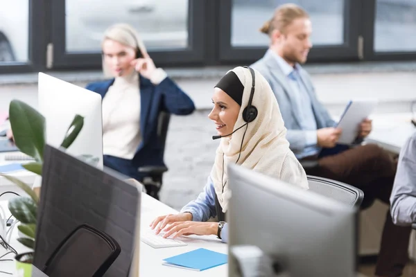 Operador de centro de llamadas en auriculares en el lugar de trabajo - foto de stock