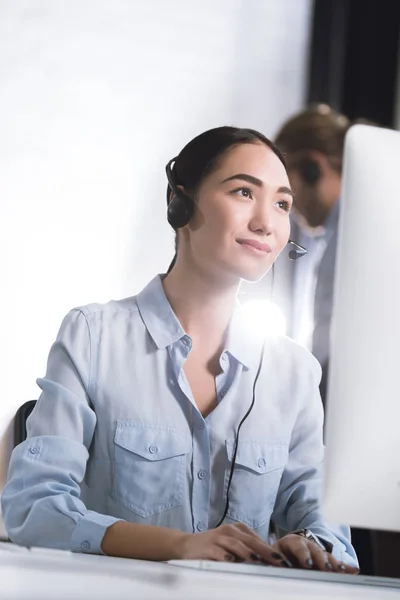 Asian call center operator in headset — Stock Photo