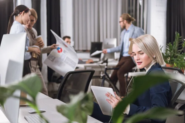 Femme d'affaires dans les écouteurs avec tablette — Photo de stock