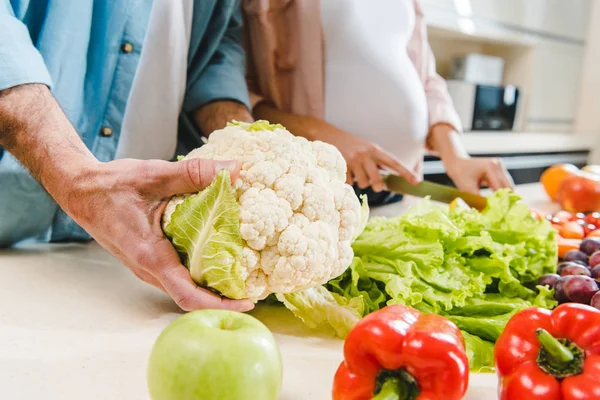 Homme et femme enceinte à la cuisine avec des légumes — Photo de stock