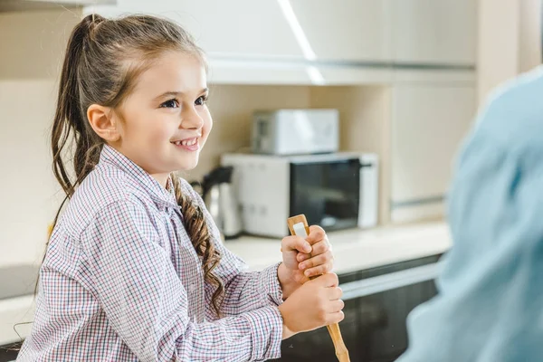 Kid mixing with ladle — Stock Photo