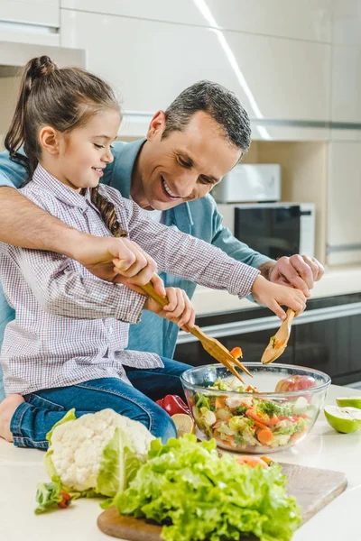 Padre con figlia mescolando insalata in ciotola — Foto stock