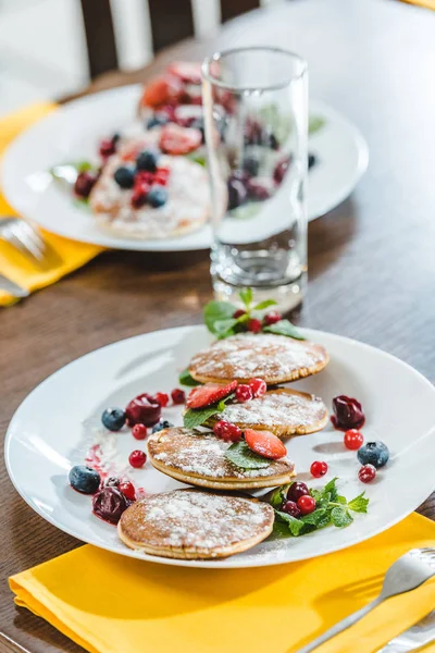 Pancakes with berries on plates — Stock Photo