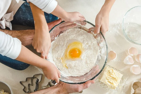 Mani che tengono la farina con l'uovo in ciotola — Foto stock