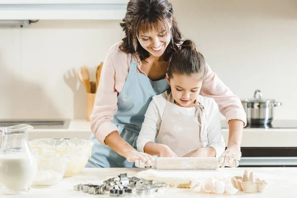 Mother with daughter rolls out dough — Stock Photo