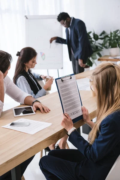 Überarbeitete Geschäftsfrau in Konferenzsaal hält Vertrag im Büro auf den Kopf — Stockfoto