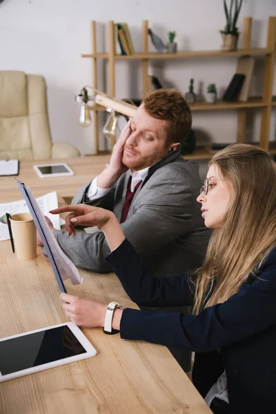 Exhausted businesspartners lookign at documents together at office — Stock Photo