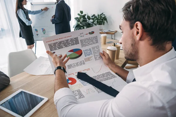 Nahaufnahme eines jungen gutaussehenden Geschäftsmannes, der Dokumente im Büro entdeckt — Stockfoto