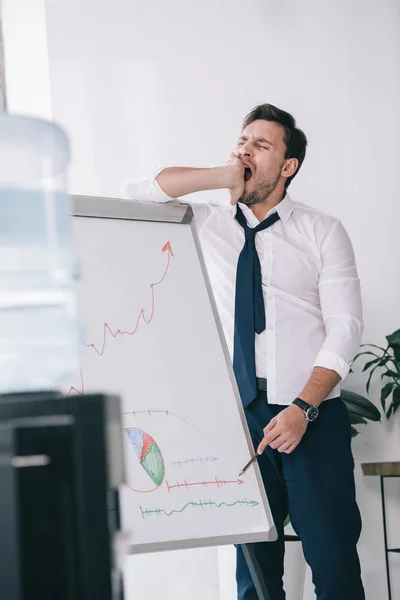 Yawning sleepy businessman making presentation at office — Stock Photo