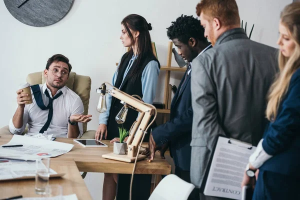 Exhausted zombie like businesspeople talking to boss at office — Stock Photo