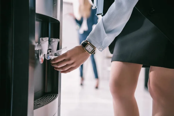 Cropped shot of businesswoman pouring water from dispenser — Stock Photo