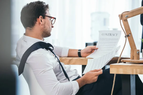 Desordenado empresario sobrecargado de trabajo descubriendo contrato en el lugar de trabajo - foto de stock