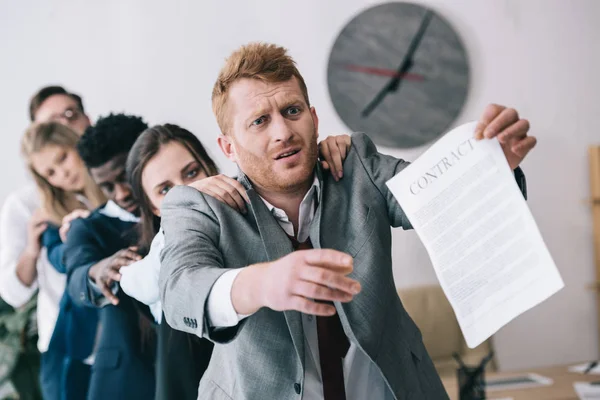 Exhausted zombie like businesspeople standing in row and holding contract — Stock Photo