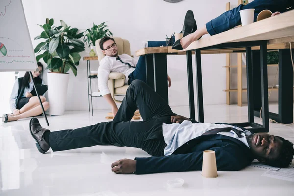 Empresarios exhaustos durmiendo en la sala de conferencias en la oficina - foto de stock