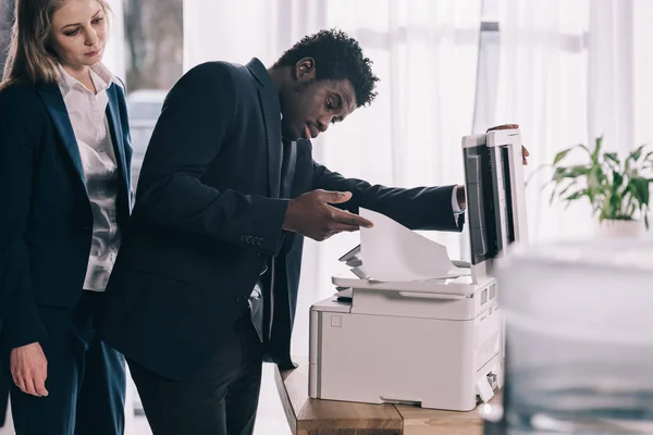 Gestionnaire afro-américain surmené en utilisant copieur au bureau — Photo de stock