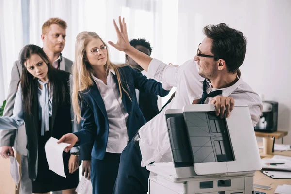 Gruppo di imprenditori che lottano per la fotocopiatrice in ufficio — Foto stock