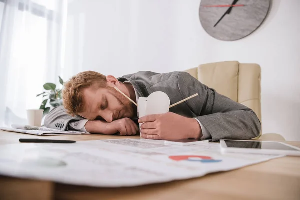 Erschöpfter junger Geschäftsmann schläft mit Schachtel Nudeln zum Mitnehmen am Arbeitsplatz — Stock Photo