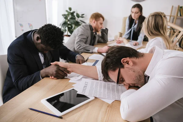 Sleeping business partners shaking hands in conference hall — Stock Photo